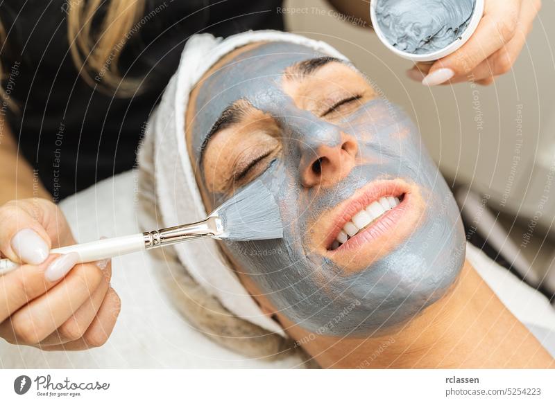 Kosmetikerin macht Totes Meer Schlamm Maske auf Gesicht für Verjüngung auf der Kosmetologie-Salon. entspannend Hautpflege Schönheitschirurgie Dermatologie