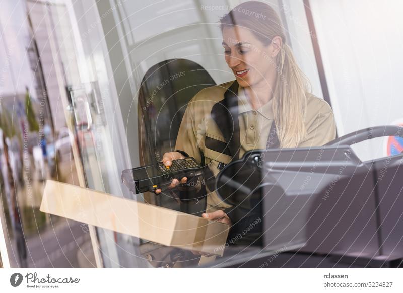 Lieferwagenfahrer mit Barcode-Scanner bei der Kontrolle eines Pakets in einem Lieferwagen in der Stadt Beteiligung Laserscanner Computer-Touchscreen berührend