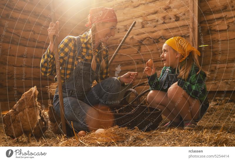 Stolze Hühnerzüchterin und ihre Tochter zeigen die Bio-Eier ihrer Hühner, die in einem Hühnerstall produziert werden Inszenierung Kind Korb Frau Landwirtschaft