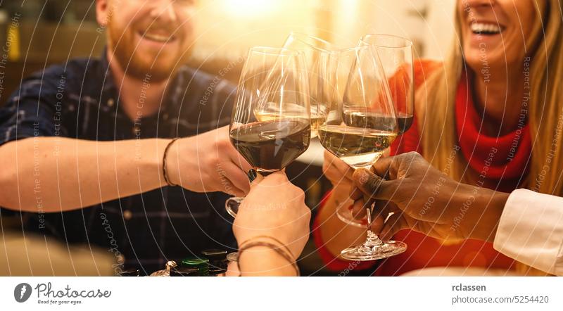 Glückliche Freunde stoßen mit Gläsern an, um zu lächeln und auf den Wein in einem italienischen Cocktailbar-Restaurant anzustoßen - Junge und alte Leute genießen die Vorspeise vor dem Abendessen, Fokus auf Weingläser, Bannergröße