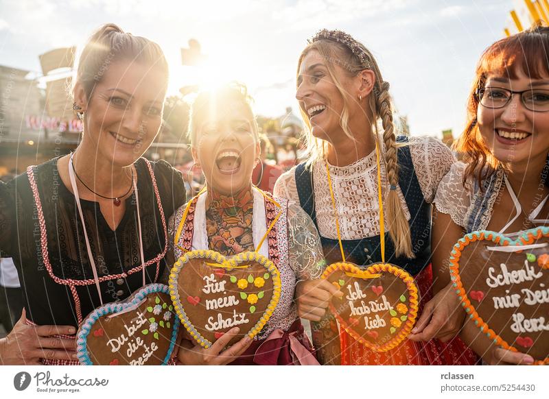 Frauen in traditioneller bayerischer Kleidung Dirndl mit einem Schenk mir dein Herz, Für meinen Schatz, Ich hab dich lieb auf Lebkuchenherz geschrieben, Oktoberfest
