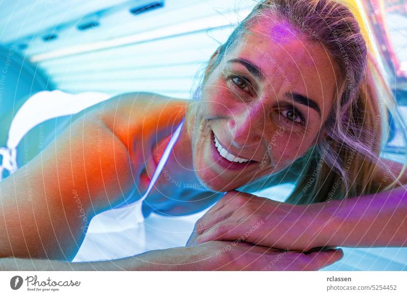 glückliche Frau, die sich im Solarium bräunt und lächelt Bett Bräunen Sonnenbad Salon Menschen Sommer Frühling Licht Spa Mädchen Gesundheit Schönheit Lifestyle