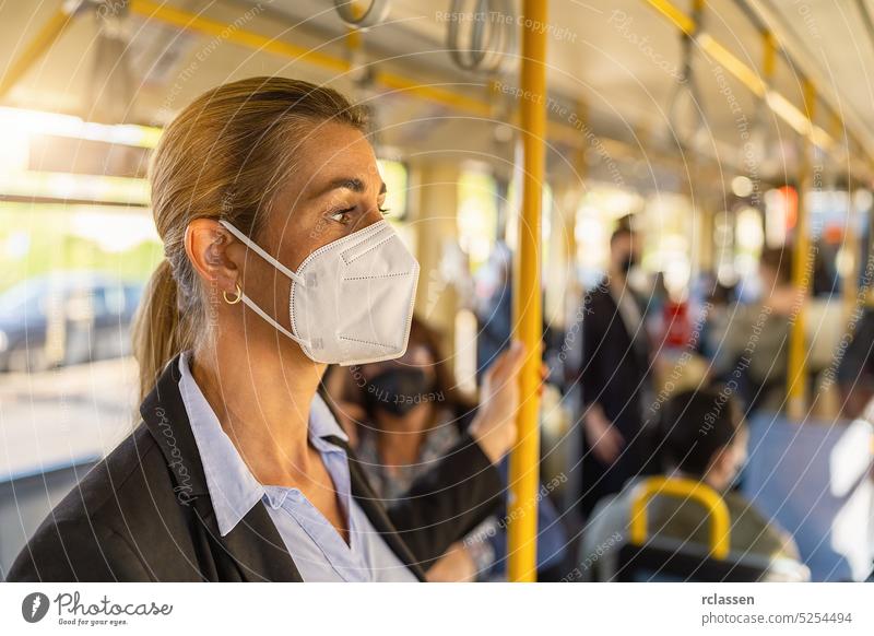 Frau mit medizinischer FFP3-Maske in der U-Bahn ffp2-Maske Handgriff Zug Großstadt tragend Coronavirus Menschen Berufsverkehr Stehen Gesunder Lebensstil Person