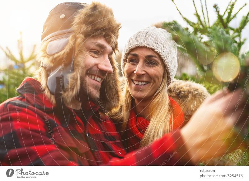 Verliebtes Paar auf der Suche nach einem Weihnachtsbaum mit Bokej-Hintergrund Kiefer Weihnachten Frau Menschen Mann Baum Liebe Winter Mädchen Sale Lächeln