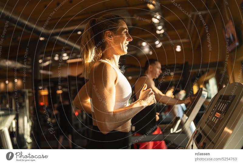 Menschen, die in einem Fitnessstudio auf einem Laufband laufen Mann Lifestyle Maschine Sportbekleidung sportlich Frau Training Übung Person Spaß jung schön