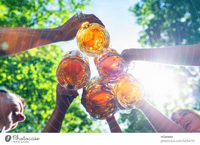 Fünf Freunde, Männer und Frauen, die sich im Biergarten amüsieren und mit Bier anstoßen, München, Deutschland Wasserhahn Hände brezen bayerisch Stadtfest Bayern