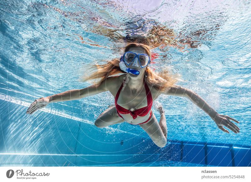 Frau mit Schnorchelmaske taucht im Schwimmbad eines Spa-Hotels unter Wasser Sinkflug Wassersport thermisch Resort platschen Lächeln Pool schwimmen Mode schön