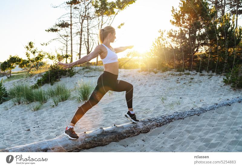 Junge Frau übt Yoga auf einem Baumstamm am Strand am Morgen Sonnenuntergang Sonnenaufgang Joggen Athlet passen Übung Training joga Chi Krieger Pose Frieden