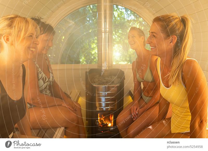 Freundinnen haben Spaß in der Holzfass-Sauna im Sommer in Norwegen. Entspannen Sie sich und genießen Sie den Urlaub, während Sie sich in der finnischen Saunakabine entspannen.