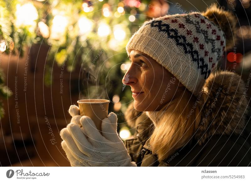 Frau vor Weihnachtsbaum auf Wintermarkt trinkt Glühwein Weihnachten Wein Baum Mädchen Lifestyle Feiertag Lichter Spaß jung schön Saison Dekoration & Verzierung