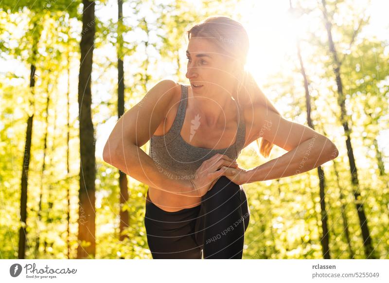 fitte und sportliche junge Frau beim Stretching im Park Sport passen Training junges Mädchen Sportbekleidung Läufer Übung Jogger Muskel außerhalb Körpertraining
