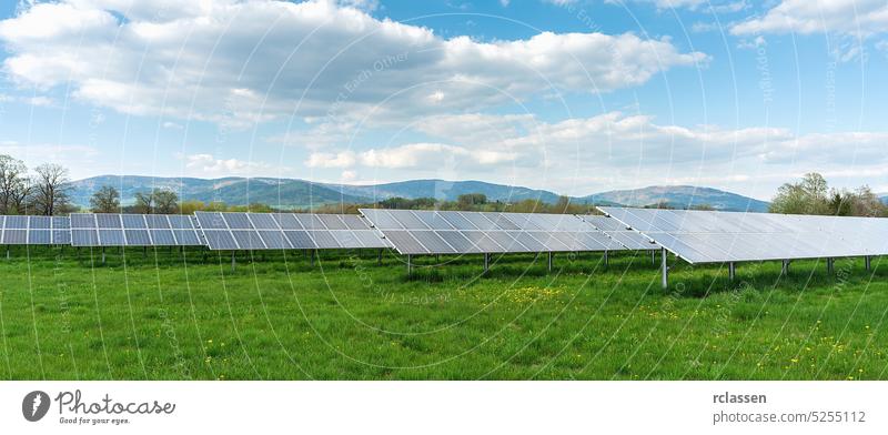 Sonnenkollektor unter blauem Himmel mit Sonne. Grünes Gras und bewölkter Himmel. Alternative Energie Konzept Bild solar Panel sauberer Strom elektrisch