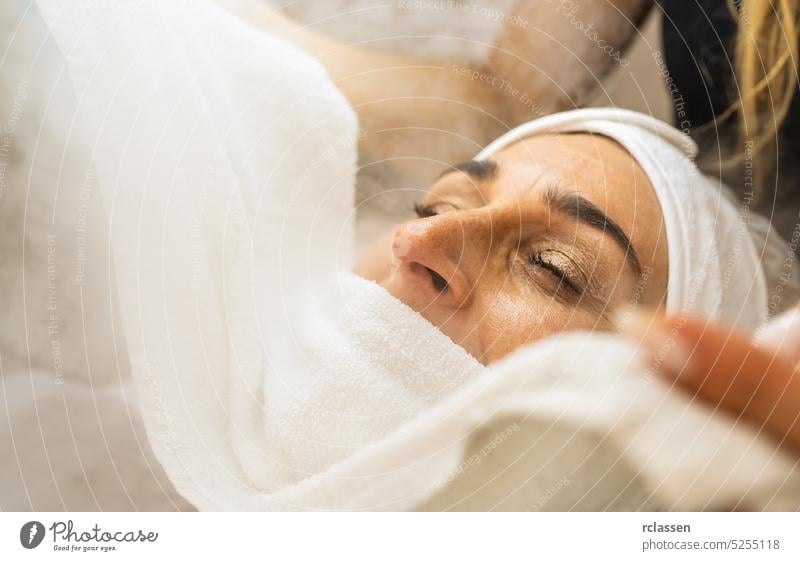 Schönheitsbehandlung des Gesichts mit Ozon-Gesichtsdampfer im Schönheitszentrum Massage Sahne Verdunstung Handtuch Therapie Gesichtsbehandlung Dampfschiff