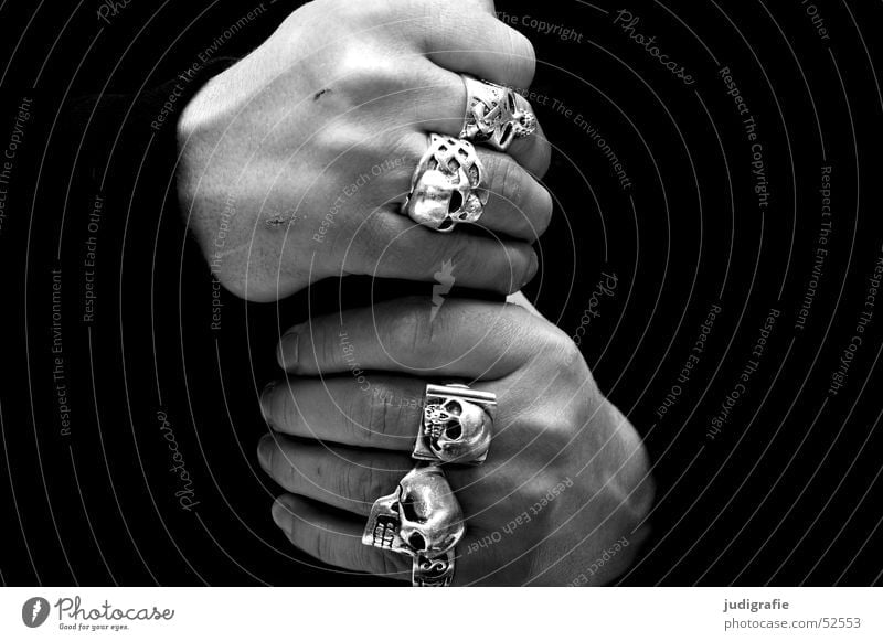 Männliche Hände mit Totenkopfringen Schwarzweißfoto Nahaufnahme Detailaufnahme Hintergrund neutral Mensch maskulin Mann Erwachsene Hand Finger Schmuck Ring