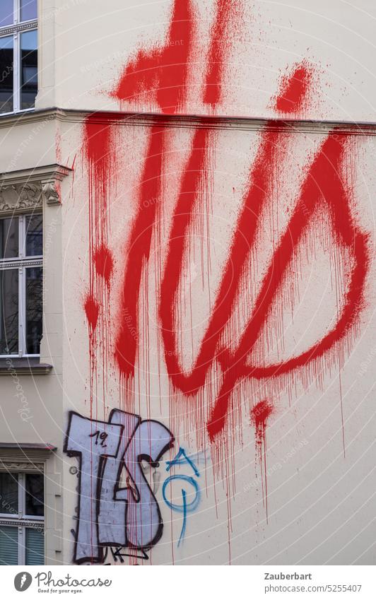 Flammend rote Buchstaben und Tags zerfließen auf heller Gründerzeit-Fassade Graffiti taggen sprayer flammend buchstaben schmiererei sachbeschädigung hässlich