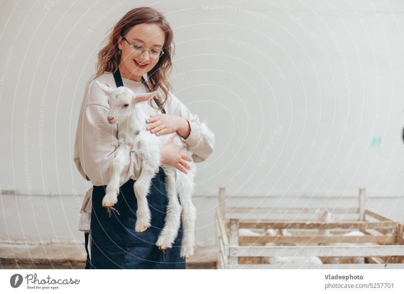 Bäuerin mit Ziege auf dem Öko-Bauernhof für Molkereiprodukte Person Landwirt Frau Beteiligung Kind ländlich Tier niedlich Mädchen Säugetier Liebe Pflege anheben