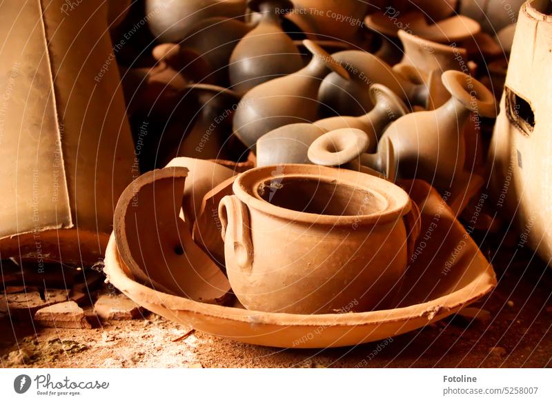Vasen, eine Schale, ein Topf, Scherben und alte Kartons liegen auf dem Boden einer lange verlassenen Töpferei. Ton Tonwaren braun Handwerk Töpferwaren Keramik