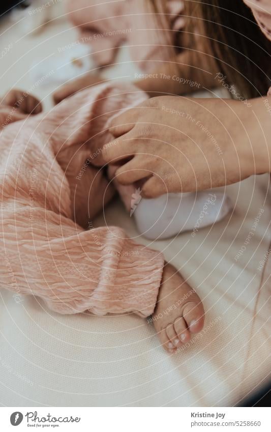 Mutter zieht Babyfüße mit Socken an Fuß Socken anziehen Zehen Mensch Körperteile