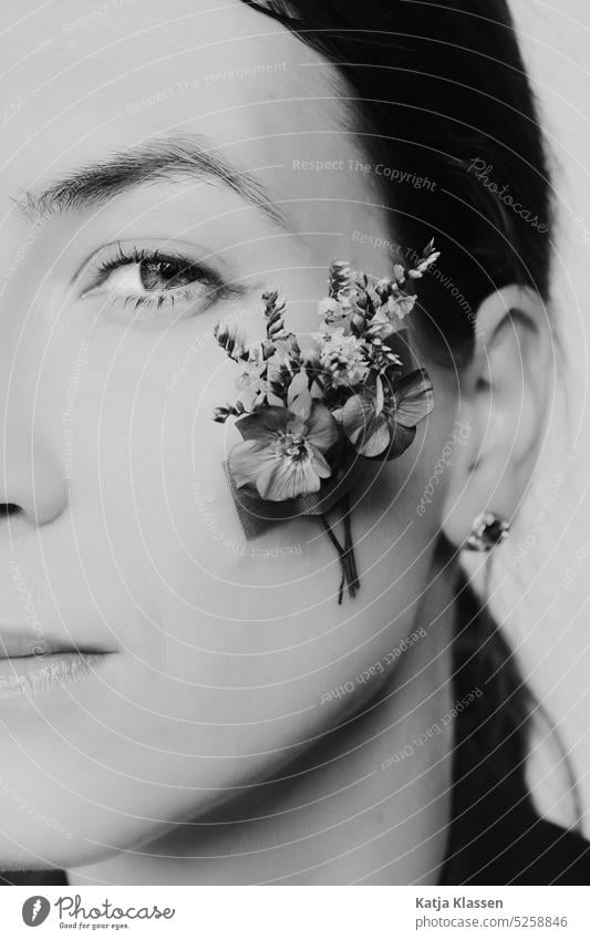 Porträt einer jungen Frau mit Blumen an der Wange Junge Frau Schwarzweiß Auge Augenbraune Blick Lippen Wimpern schön Haut Haare & Frisuren Mund Nase Gesicht