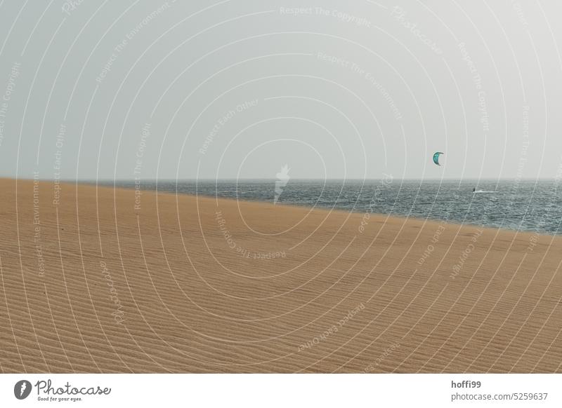 Wüstenlandschaft am Atlantik mit Kitesurfer im Hintergrund Düne heiß Dürre Strand Hügel Ozean gleißend kapverdische Inseln Wassersport Kitesegel Kitesurfen