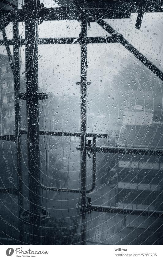 Versperrte Sicht durch ein Baugerüst und Regenwetter regnerisch Regentropfen Fensterscheibe Gerüst Scheißwetter urban Stadt schlechte Sicht Sanierung