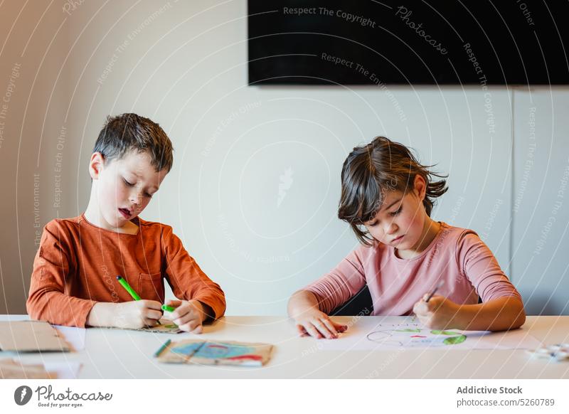Geschwister malen gemeinsam Umweltplakate Geschwisterkind zeichnen Plakat Lektion Zusammensein Schule Ökologie Fokus Papier Junge Mädchen Bruder Schwester