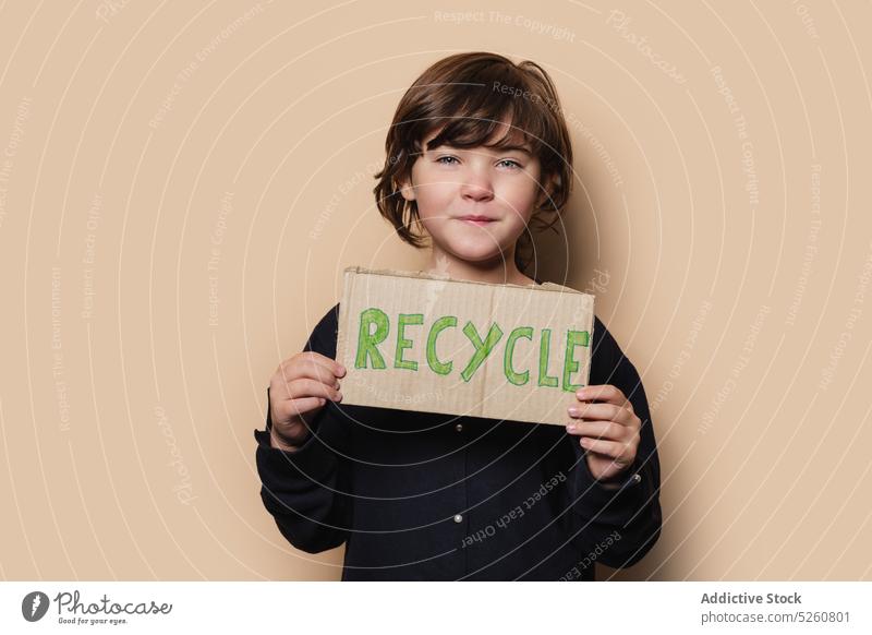 Mädchen zeigt Recycle-Plakat in die Kamera wiederverwerten plakatieren zeigen protestieren Aktivist Umwelt Ökologie Antwort Schachtel Kind Oberbekleidung Mantel