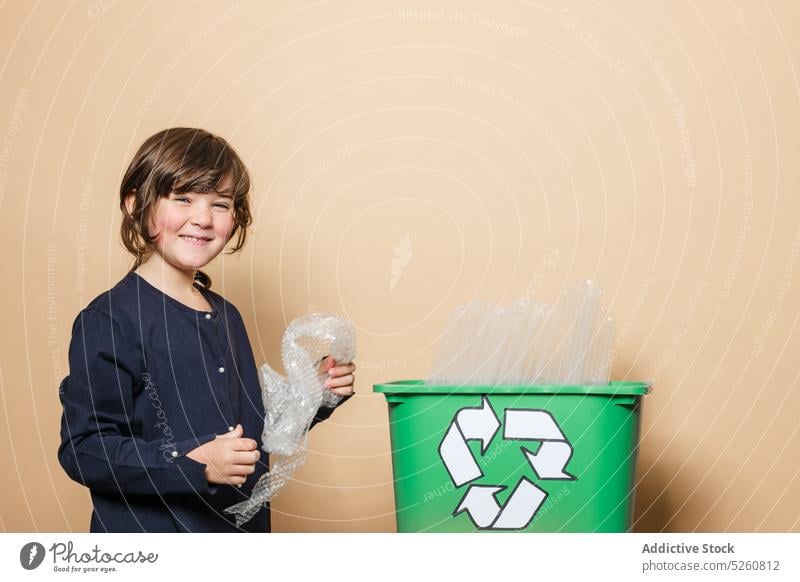 Fröhliches Mädchen lächelt und sortiert Müll wiederverwerten Lächeln Kasten Glück Ökologie Symbol sortieren Kind lässig heiter positiv froh offen Glas