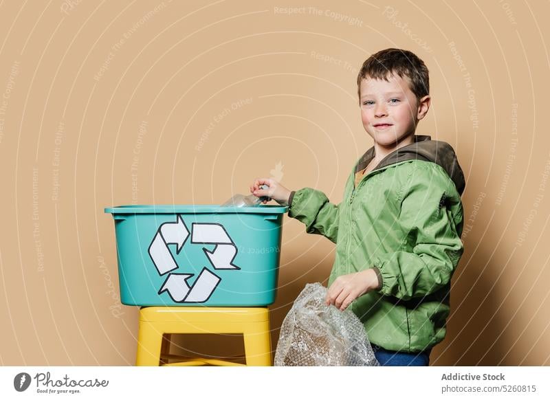 Junge wirft Abfall in die Recycling-Box wiederverwerten Kasten Lächeln sparen Aktivist sortieren Kunststoff Umwelt Kind Paket Flasche Deckblatt Müll heiter