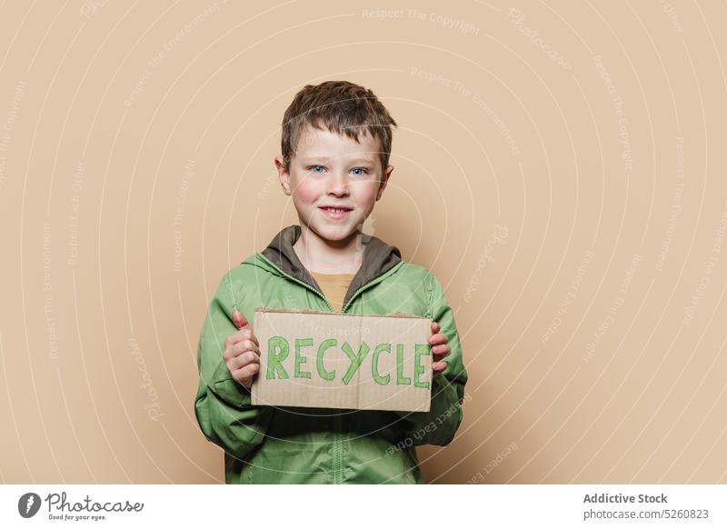 Junge zeigt Recycle-Plakat in die Kamera wiederverwerten plakatieren zeigen protestieren Aktivist Umwelt Ökologie Antwort Schachtel Kind Oberbekleidung Mantel