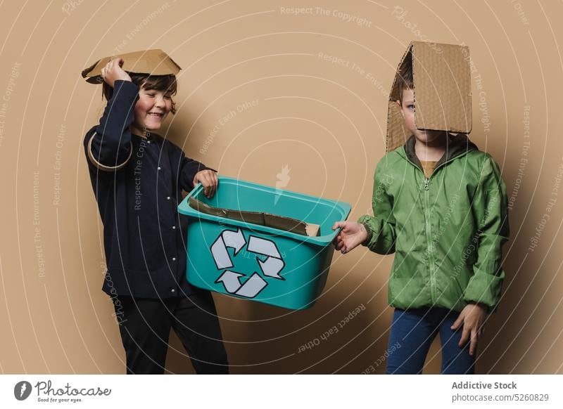 Geschwister spielen mit Pappstücken Geschwisterkind Karton wiederverwerten Kasten Kinder Glück Zusammensein führen Symbol Junge Mädchen Schwester Bruder