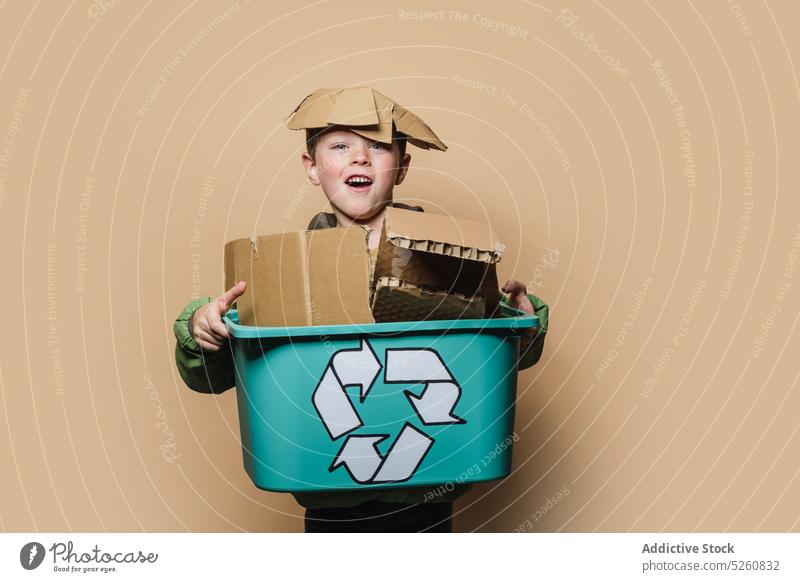 Glücklicher Junge mit Kartonschachtel Kasten führen Schachtel wiederverwerten Umwelt Spielfigur Symbol spielerisch Kind Papier sortieren Ökologie