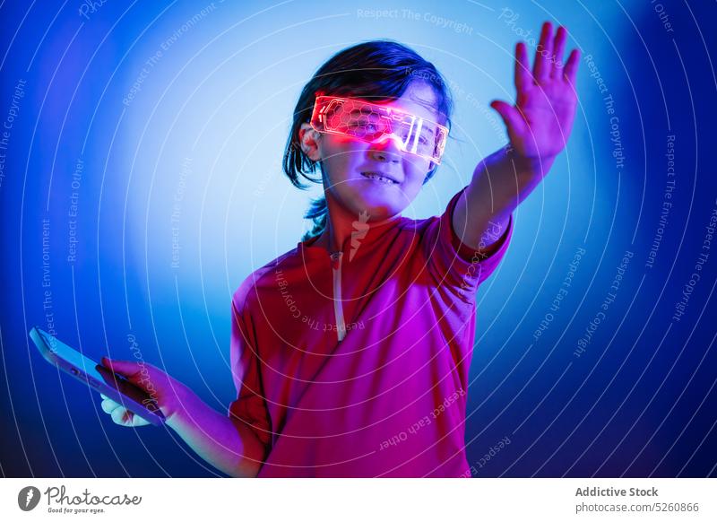 Mädchen mit VR-Brille und Smartphone spielt ein Spiel in der virtuellen Welt Kind klug Schutzbrille Videospiel berühren unsichtbar Objekt Air Funktelefon