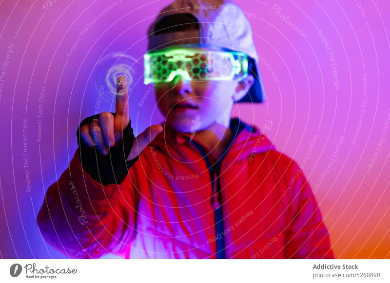Futuristischer Junge, der mit einer digitalen Schnittstelle interagiert interagieren futuristisch Cyberspace Kontrolle Presse neonfarbig leuchten hell Stil