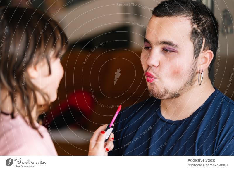 Fröhliches Mädchen trägt Lippenstift auf Mann auf Vater Tochter bewerben spielen Make-up Spaß haben zu Hause Zusammensein Bonden Kindheit positiv Kosmetik