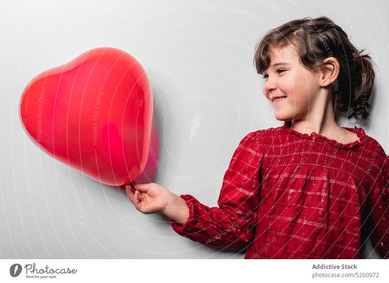 Glückliches Mädchen hält rotes Herz feiern Luftballon Valentinstag (Heiliger Valentinstag) Feiertag Liebe niedlich romantisch Symbol Kind Form Kindheit Kleid
