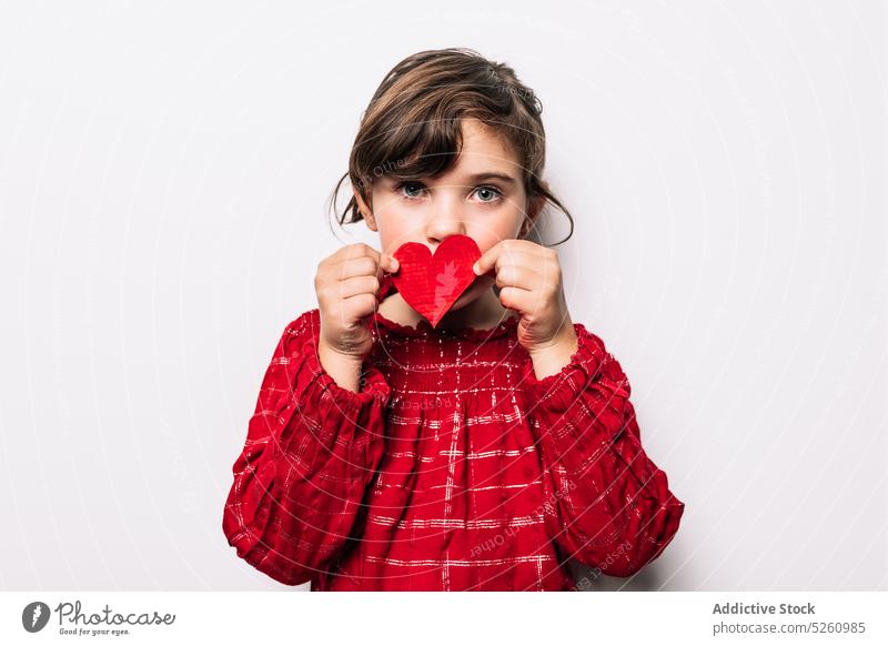Mädchen bedeckt Mund mit Herz Papier Deckel Mund Liebe Valentinstag (Heiliger Valentinstag) Feiertag feiern Stil niedlich festlich Symbol rot Kind hell Anlass