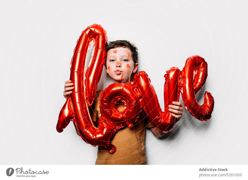 Junge mit Liebesballon, der die Lippen schmollt Herz schmollende Lippen Valentinstag (Heiliger Valentinstag) Luftballon feiern Kuss Form niedlich Symbol