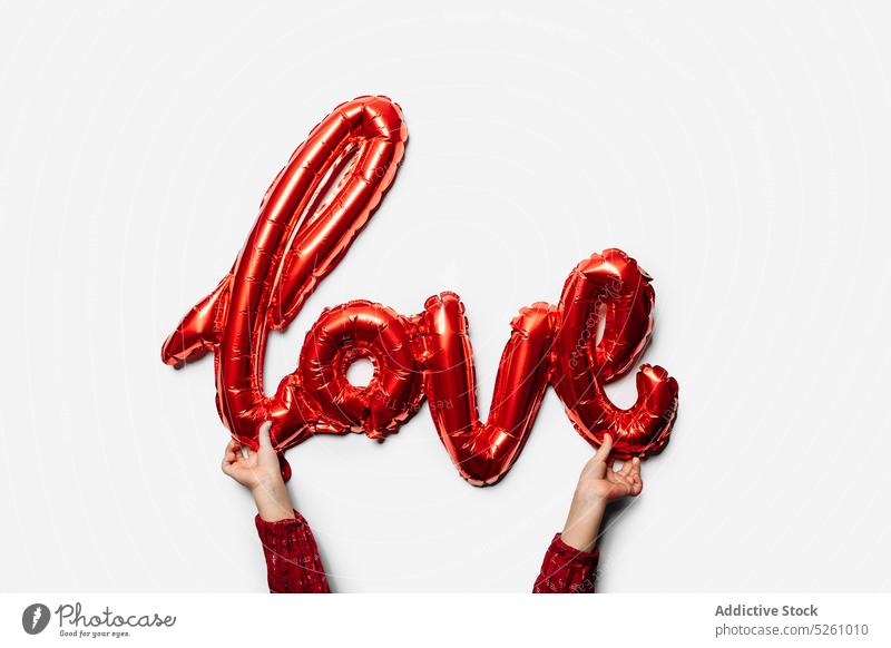 Beschnittenes Kind mit Liebesinschrift Luftballon zeigen Aufschrift Valentinstag (Heiliger Valentinstag) romantisch Symbol Feiertag Form feiern Kindheit kreativ