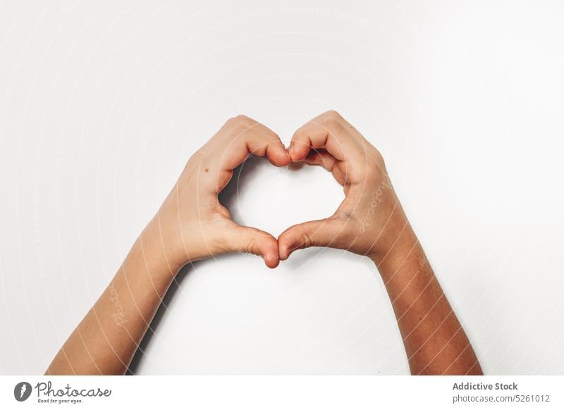 Crop Kind gestikuliert Herz mit Händen zeigen Finger Liebe Symbol Valentinstag (Heiliger Valentinstag) Zuneigung gestikulieren Zeichen Form Mädchen romantisch