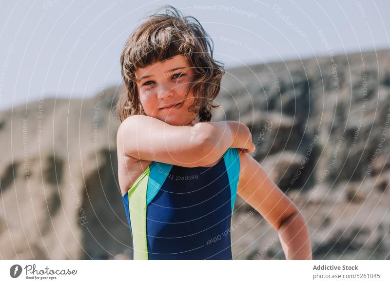 Nettes Mädchen im Badeanzug steht gegen felsige Klippe Kind ausrichten Natur wolkenlos genießen Urlaub Sommer positiv Lanzarote Papageienstrand Spanien Europa