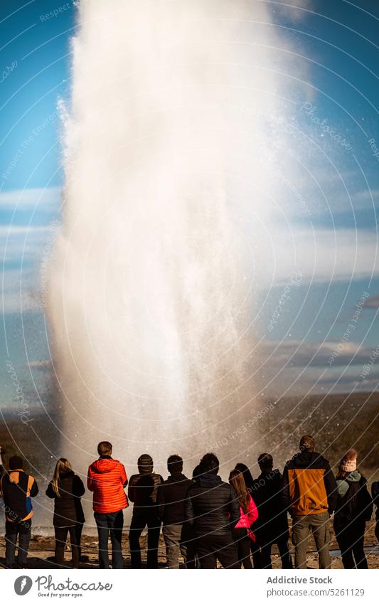 Geysir in Aktion spuckt heißes Wasser Menschen bewundern spucken Energie Kraft Reisender Tourismus Natur Island Europa Oberbekleidung erkunden reisen idyllisch