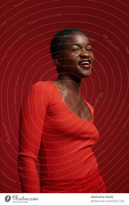 Lächelnde schwarze Frau mit roten Lippen Porträt Vorschein Geflecht Model rote Lippen Stil positiv Frisur Afroamerikaner jung ethnisch dunkles Haar