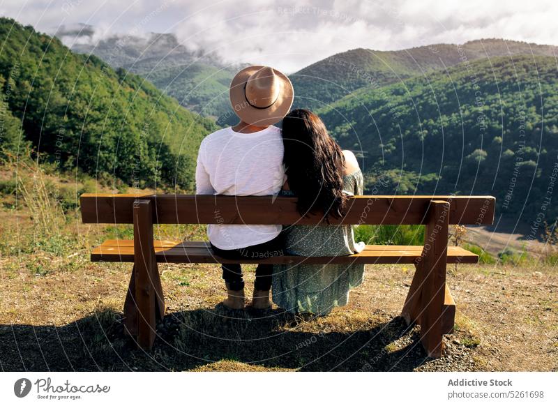 Glückliches Paar sitzt auf einer Bank in den Bergen ruhen schließen bewundern Liebe romantisch Berge u. Gebirge amourös Termin & Datum jung Zusammensein Kleid