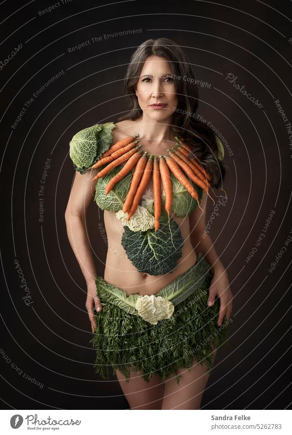 Eine Frau trägt Kleidung, die aus Gemüse besteht. Möhren Wirsing Vegetarische Ernährung Bioprodukte Gesundheit Gesunde Ernährung Vegane Ernährung grün