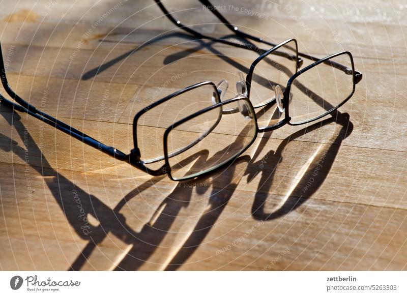 Zwei Brillen brille bügel ersatzbrille glas holz holzplatte liegen optik optiker schatten sehhilfe tisch zusammen zwei paar duo licht holztisch maserung