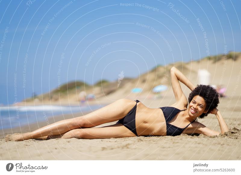 Zufriedene schwarze Frau am Strand liegend Sonnenbad Lügen Ufer Bikini MEER Bräune Meeresufer sonnig Freizeit Erholung tropisch ruhen Ausflug genießen Sommer