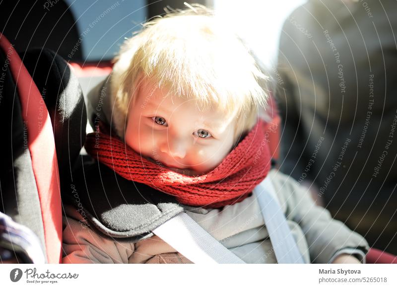Porträt eines niedlichen Kleinkindes im Autositz. Kindertransport Sicherheit PKW Sitz Baby Stuhl Gurt Fahrzeug Säugling Junge blond Minivan sicher Gesicht