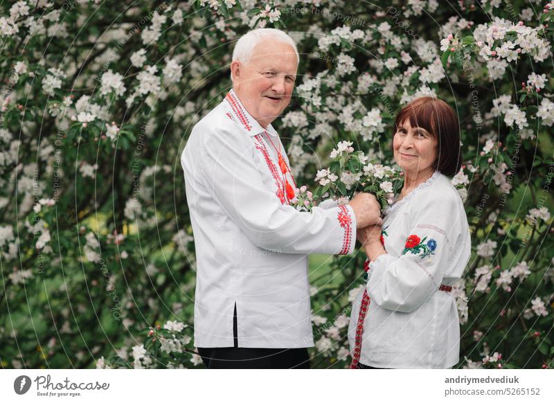 Schönes Paar in der nationalen gestickten Hemd der ukrainischen Hemden. Foto-Shooting im Frühling Garten Erwachsener Liebe reif Natur alt im Freien Eltern