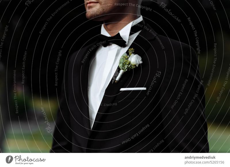 Boutonniere auf der Jacke des Bräutigams. Blume auf der Jacke eines Mannes. Ein Mann in einer Jacke mit einer Blume. Hochzeit striegeln Krawatte Anzug männlich